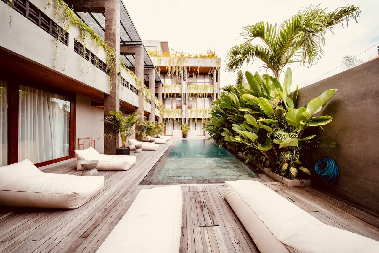 The 12-metre courtyard pool at TheHub, lined with sun loungers and palms